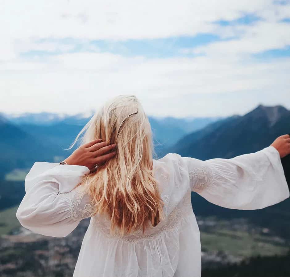 Woman with her arms out looking at the mountains